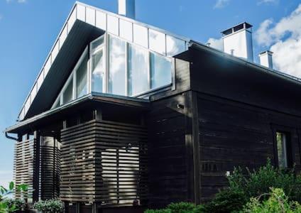a black house with glass windows on top of it at Merenranta Huvila 210 m2 in Kokkola