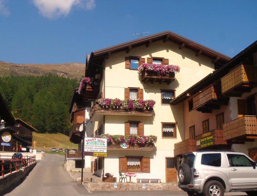 een gebouw met bloembakken aan de zijkant bij Appartamenti Sport 3000 in Livigno