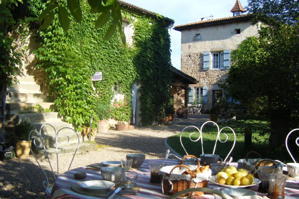 a table with plates of food on it in front of a building at Le Clos Goëlle in Moissat