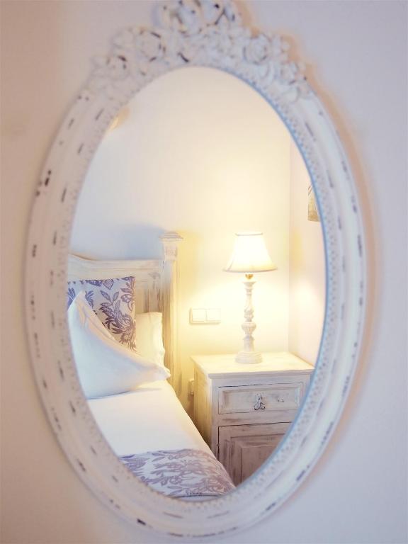 a mirror in a bedroom with a bed and a lamp at Hotel Abaco Altea in Altea