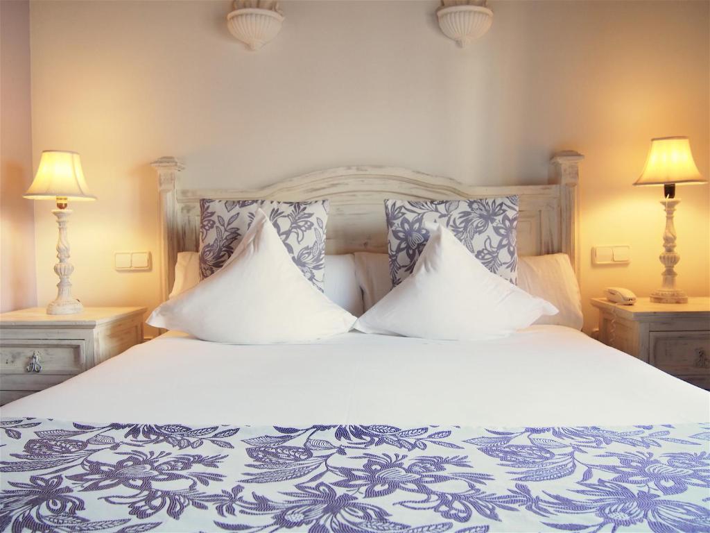 a bedroom with a large bed with two pillows at Hotel Abaco Altea in Altea