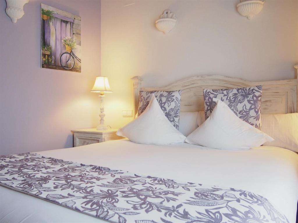a bedroom with a bed with white sheets and pillows at Hotel Abaco Altea in Altea