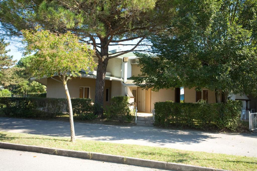 a white house with trees in front of it at Olimpia in Bibione