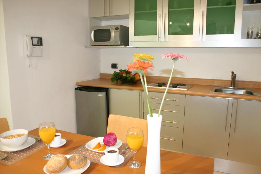 
a kitchen with a table and a vase of flowers at Hotel Piedraluna in Guatemala
