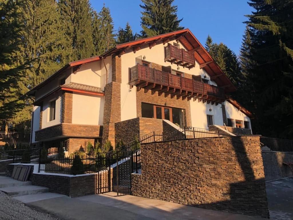 a house with a fence in front of it at Platinvm B&B in Predeal