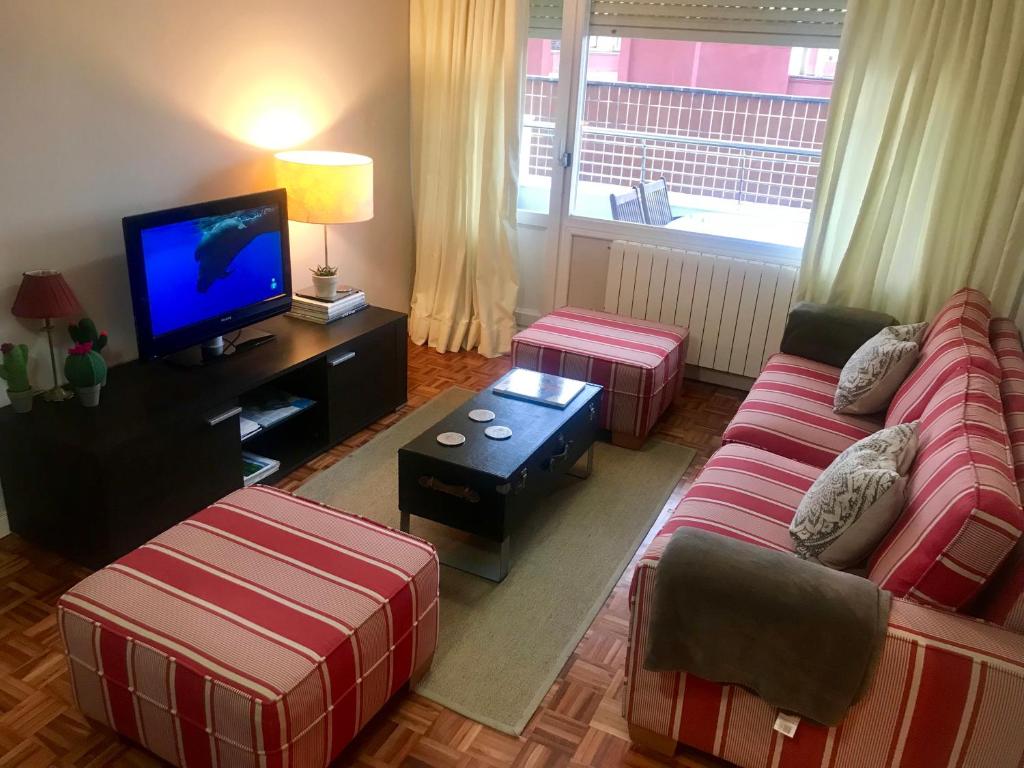 a living room with a couch and a tv at Lauramer Apartamento Bakio in Bakio