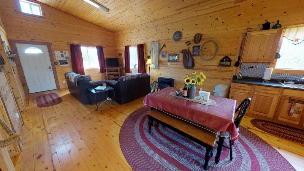 Ranch Mountain Cabin, Stunning! BBQ, Campfire, Hiking في مونتيسلو: مطبخ وغرفة معيشة مع طاولة في كابينة