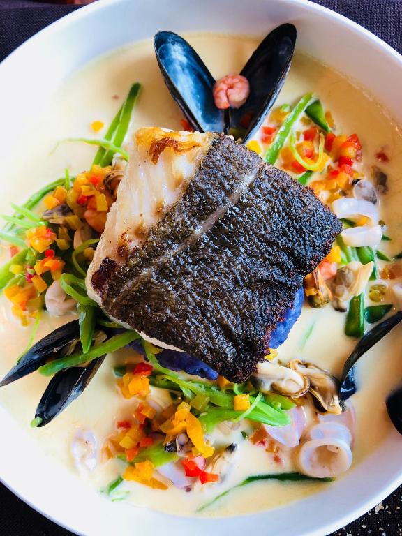 a bowl of soup with a piece of fish on top at Le Florentin in Florenville