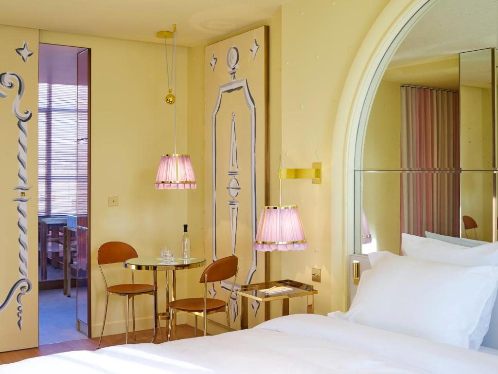 a bedroom with a bed and a table and chairs at 9Confidentiel in Paris