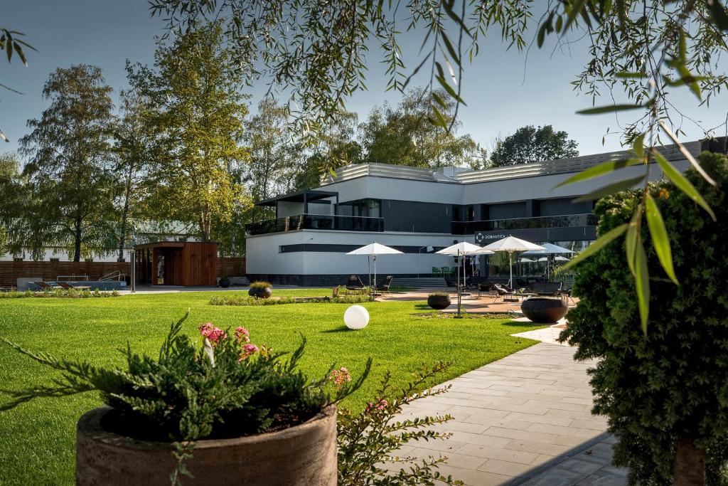 a building with umbrellas in a park at Donautica Hotel & Restaurant in Fadd-Dombori