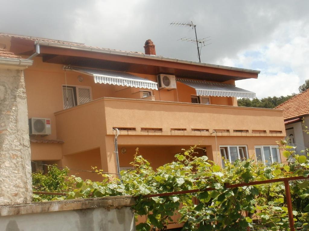 una casa con una valla delante de ella en Apartments and rooms Nediljko, en Bibinje