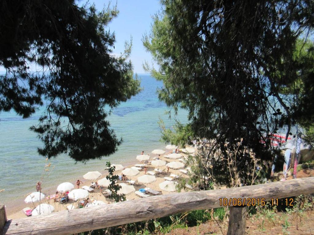 a beach with a bunch of umbrellas on the water at Litsa 1 in Metamorfosi