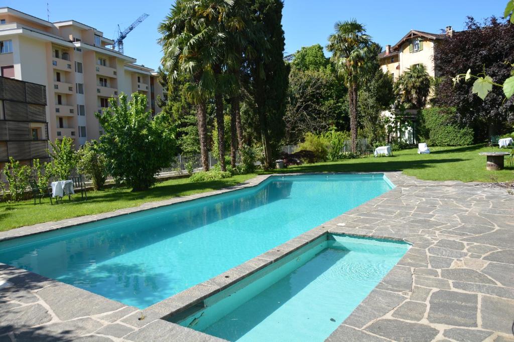 ルガノにあるHotel Villa Selvaの建物の隣の庭にあるスイミングプール