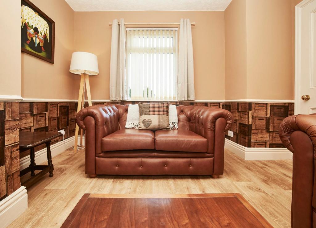 a brown leather couch in a living room at The Castle House in Whitby