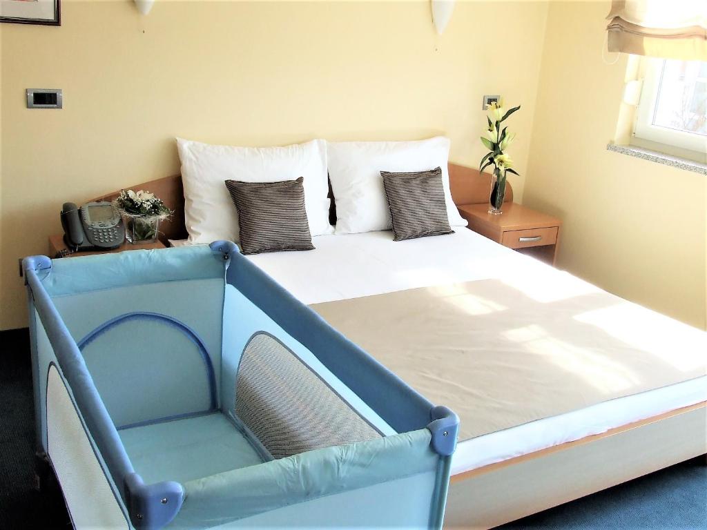 a bed with a blue frame in a bedroom at Hotel Central Slavonski Brod in Slavonski Brod