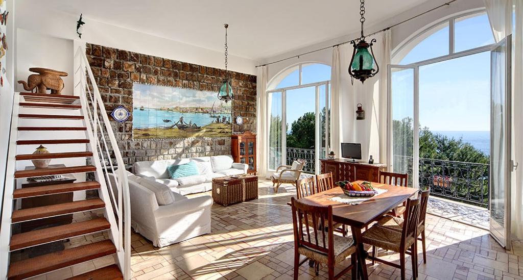 a living room with a staircase and a table and chairs at Morso di luna in Nerano