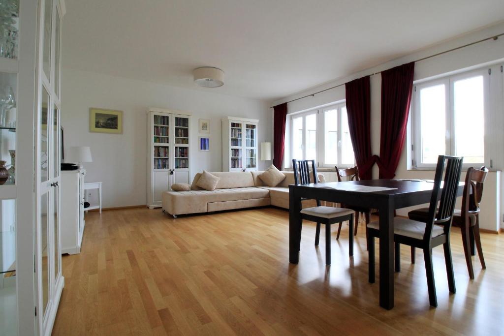 a living room with a table and a couch at Luxury city apartment - view of river and castle in Würzburg