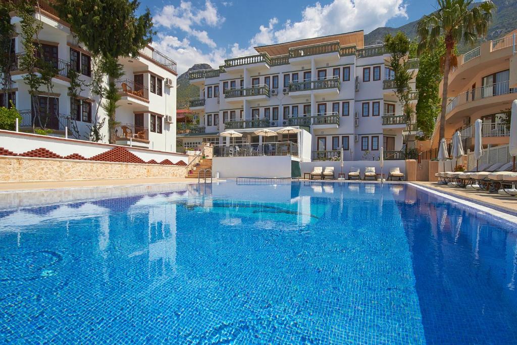 a large blue swimming pool in front of some buildings at Kalkan Dream Hotel in Kalkan