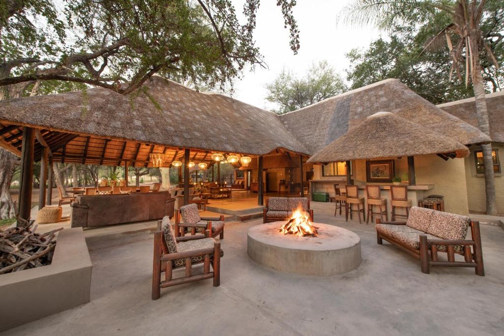 侯斯普瑞特的住宿－Malilule Safaris，一个带火坑和椅子的庭院和一座建筑