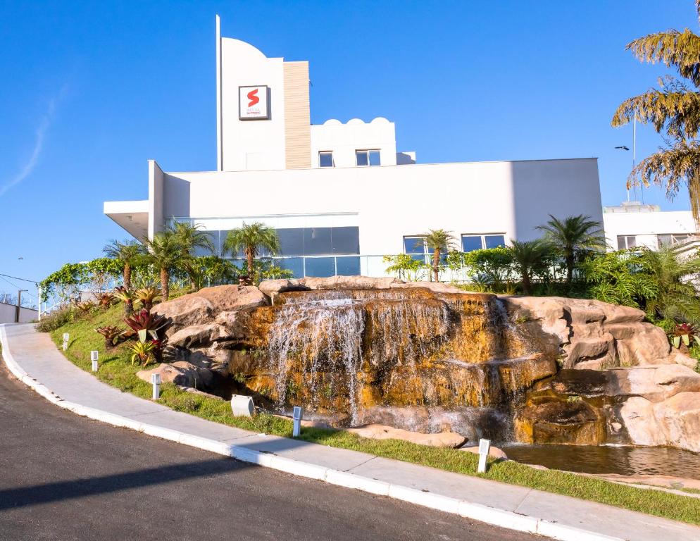 a building with a waterfall in front of a building at VOA Business Supreme Choice Confins in Lagoa Santa