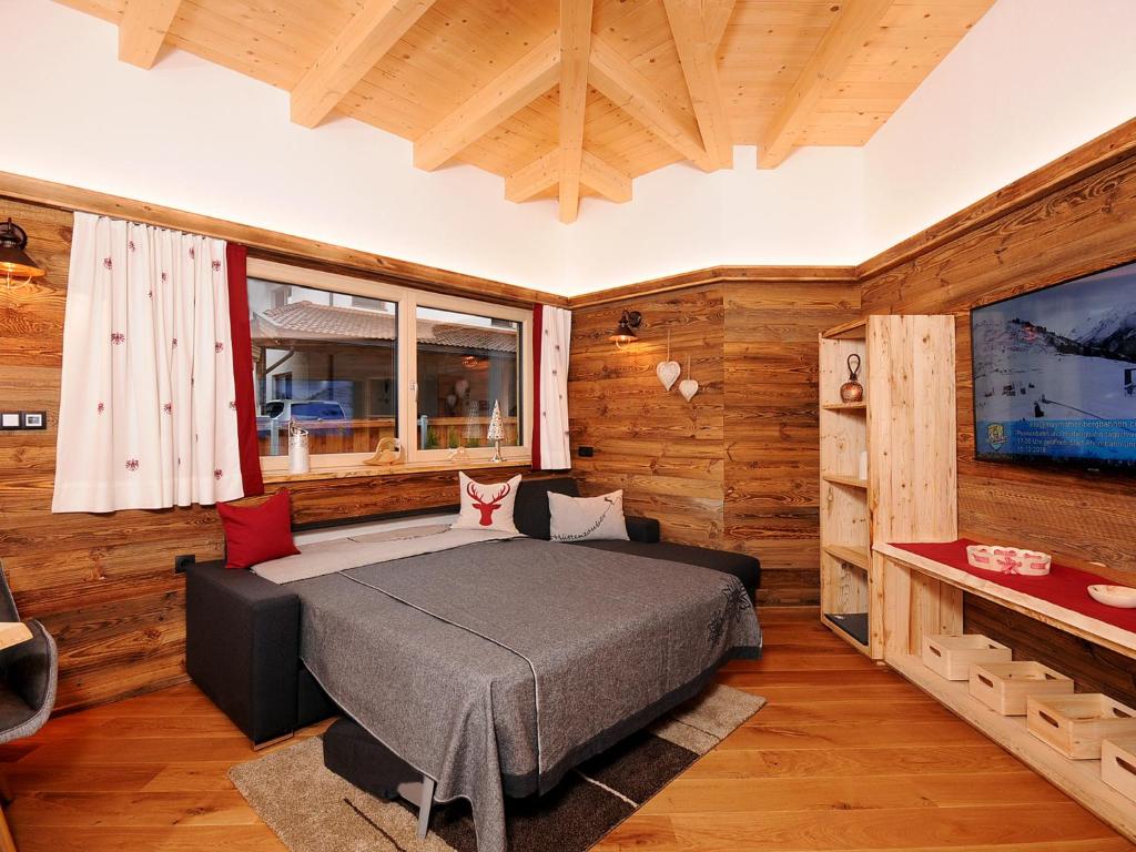een slaapkamer met een bed in een kamer met houten wanden bij Apartment Christian in Mayrhofen