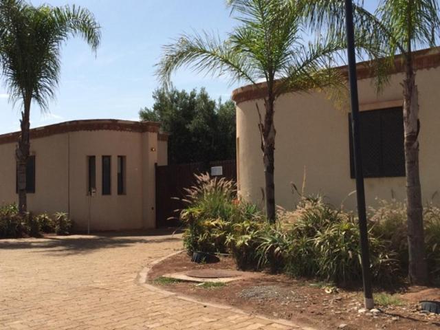 a building with palm trees in front of it at Villa Catalpas in Taroudant