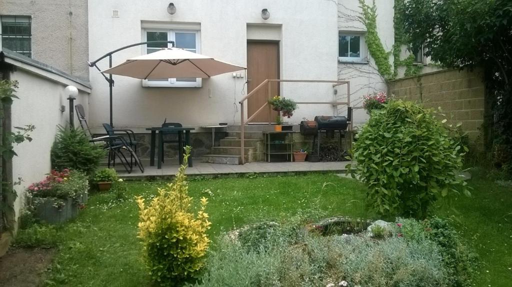 a backyard with a table and an umbrella at Duplex with garden in Prague