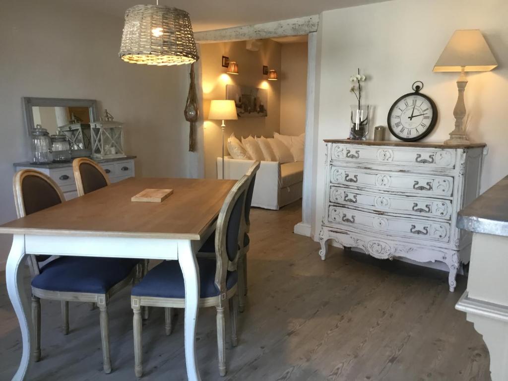 a dining room with a table and chairs and a dresser at L ANNEXE in Malaucène