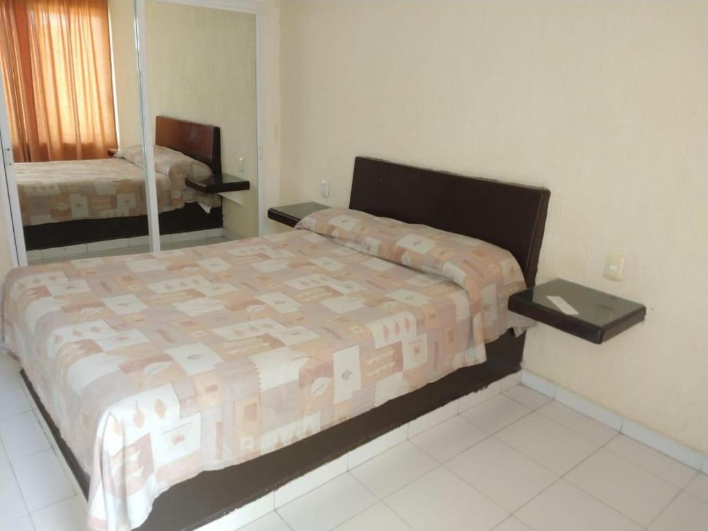 HOTEL PARAISO ACAPULCO في أكابولكو: غرفة نوم فيها سرير ومرآة
