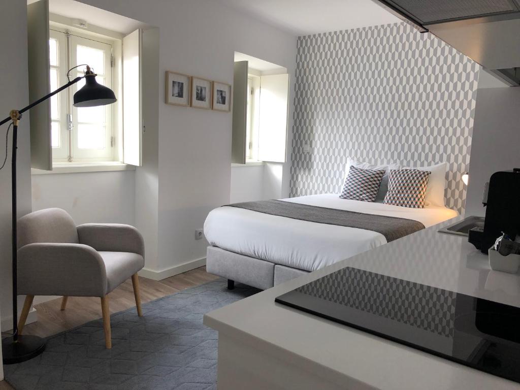 a bedroom with a bed and a desk with a laptop at São Bento na Alta in Coimbra
