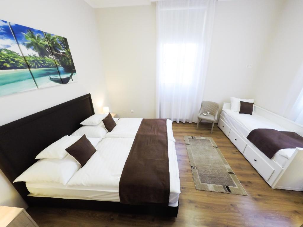 a bedroom with two beds and a painting on the wall at Szent Imre Panzió in Újkígyós