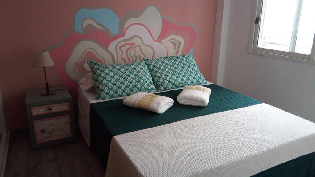 a bedroom with a bed with two pillows on it at Apartamento La Loca del Pincel in Buenos Aires