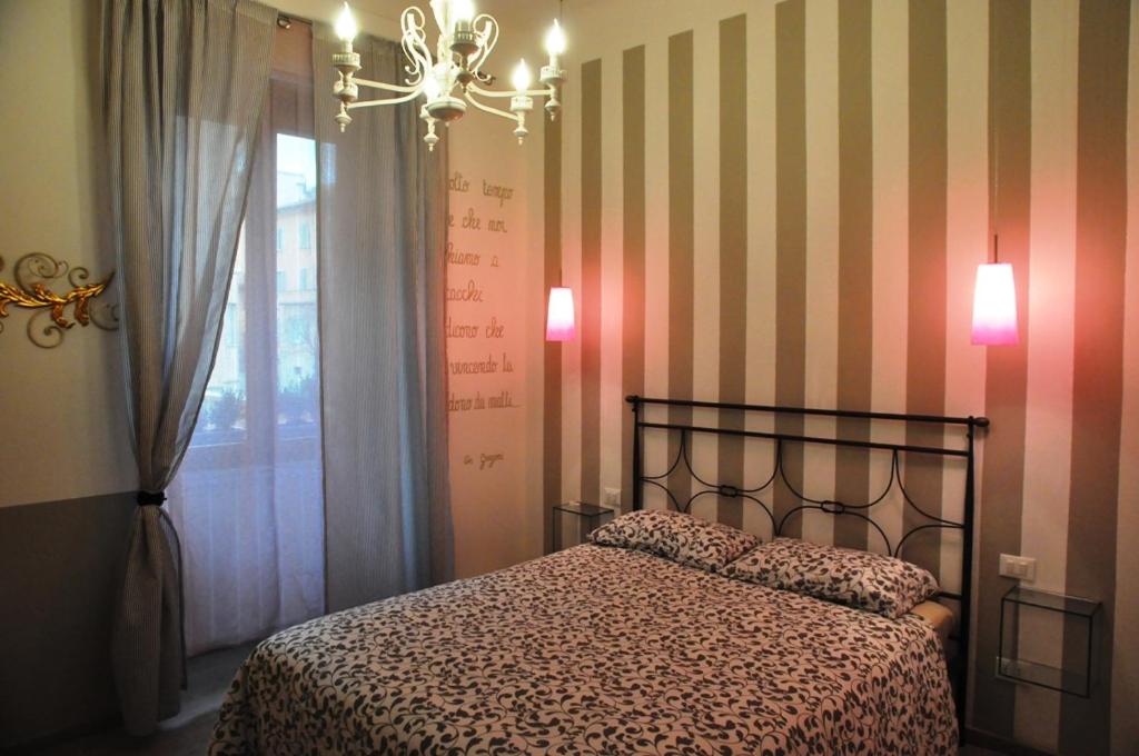 a bedroom with a bed and a window and a chandelier at Il Moscondoro di MZ in Bologna