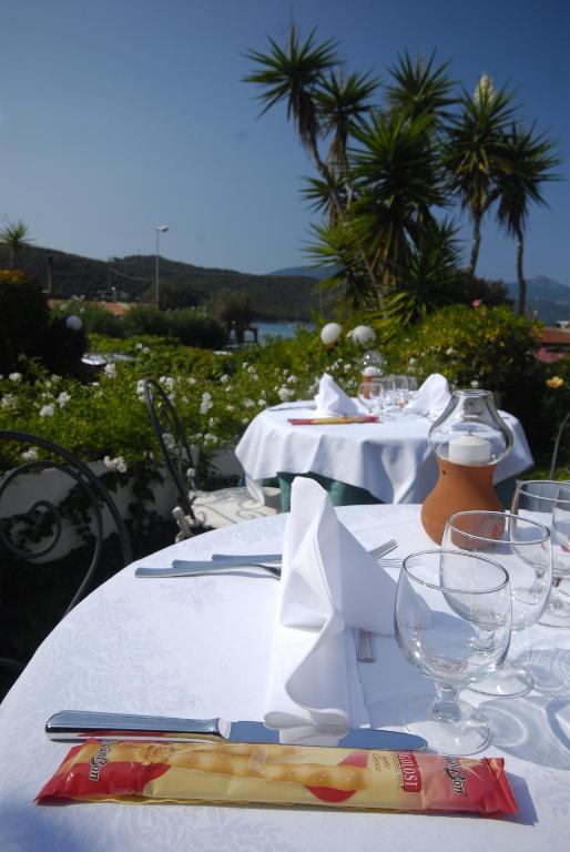 a table with a white table cloth and wine glasses at Hotel Danila in Portoferraio