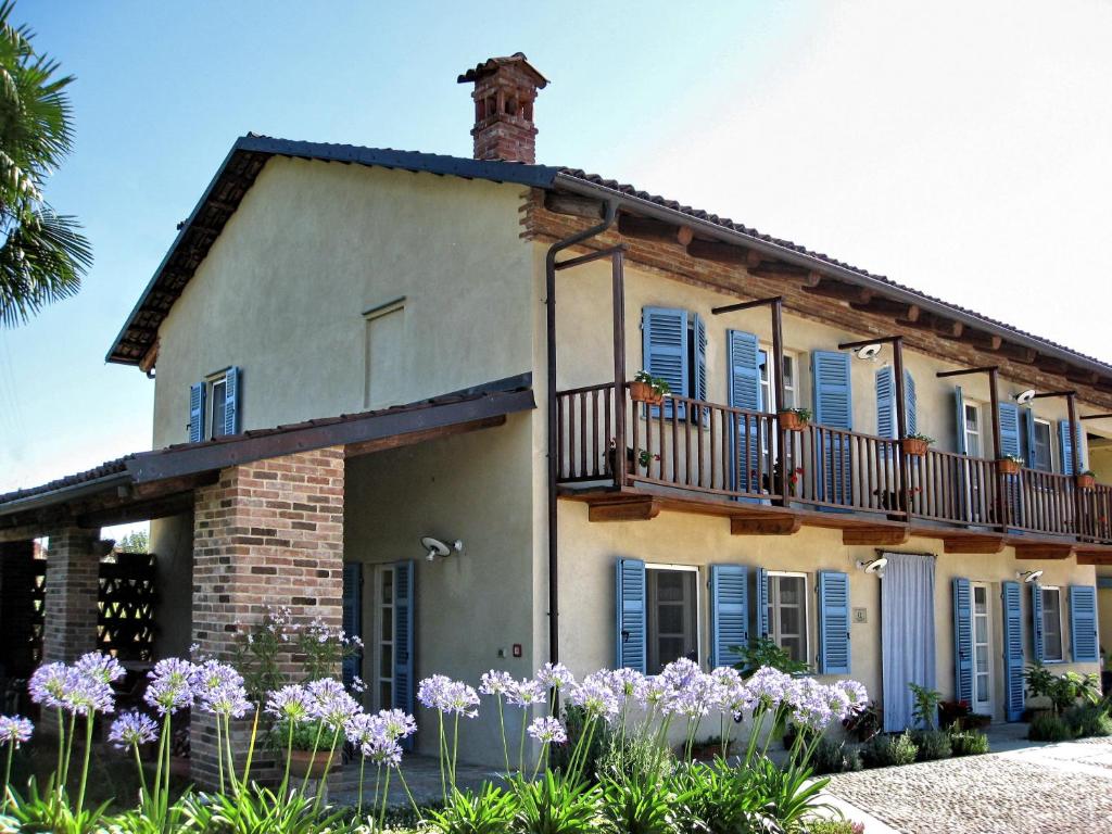 a house with a balcony and purple flowers at Agriturismo Cascina Ponchietta in Montà