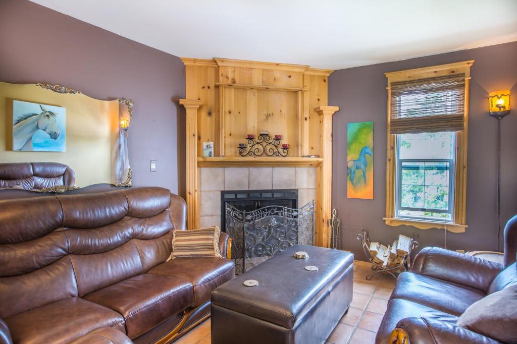 a living room with leather furniture and a fireplace at Heartwood Inn in Drumheller