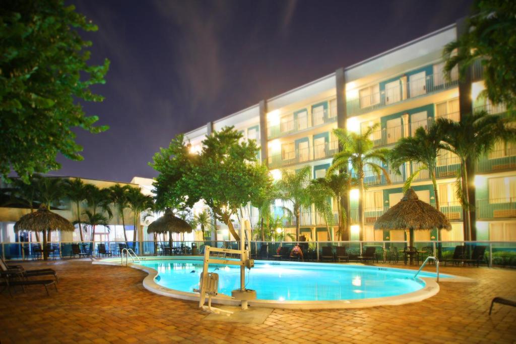 a swimming pool in front of a building at night at Fort Lauderdale Grand Hotel in Fort Lauderdale