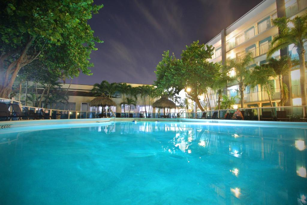Fort Lauderdale Grand Hotel في فورت لاودردال: مسبح كبير امام مبنى في الليل