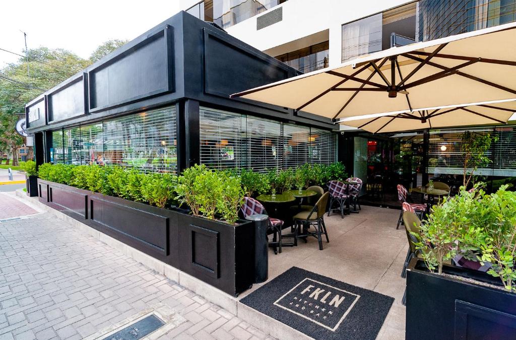 un restaurante con plantas al lado de un edificio en Roosevelt Hotel & Suites en Lima
