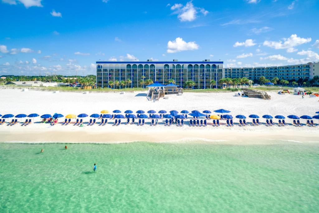 a view of a beach with umbrellas and a building at The Island Resort at Fort Walton Beach in Fort Walton Beach
