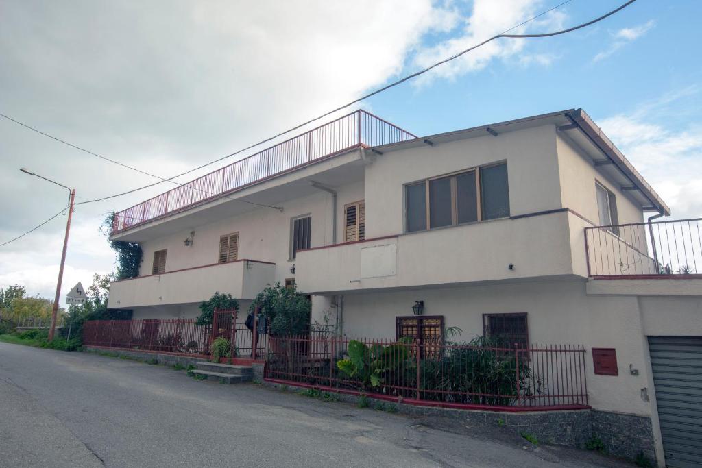 ein weißes Haus mit einem Zaun davor in der Unterkunft Rosa di Calabria in Bovalino Marina