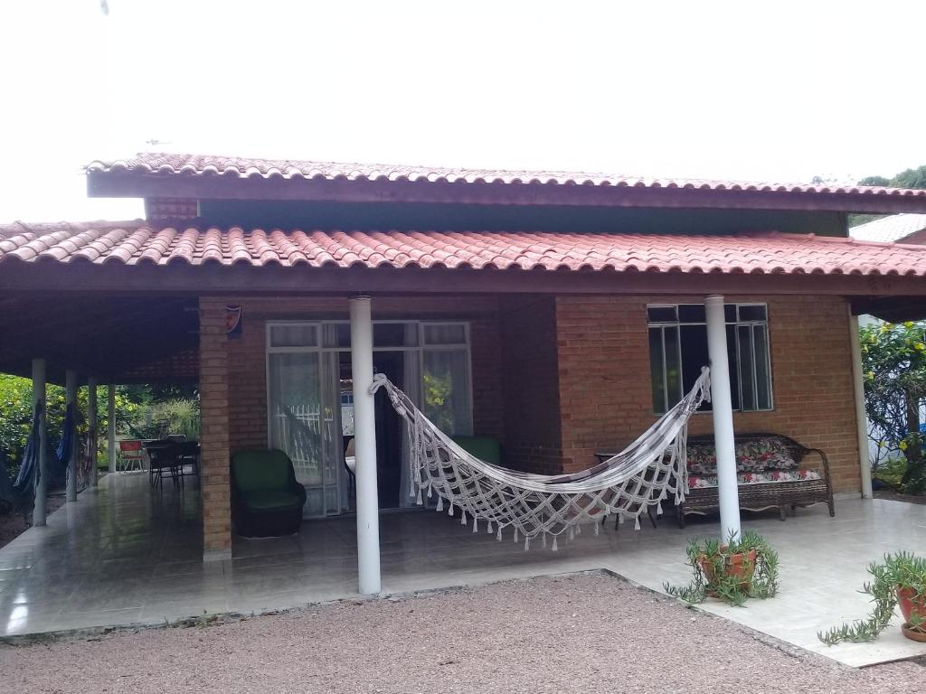 a house with a hammock in front of it at Casa das flores in Itapoa