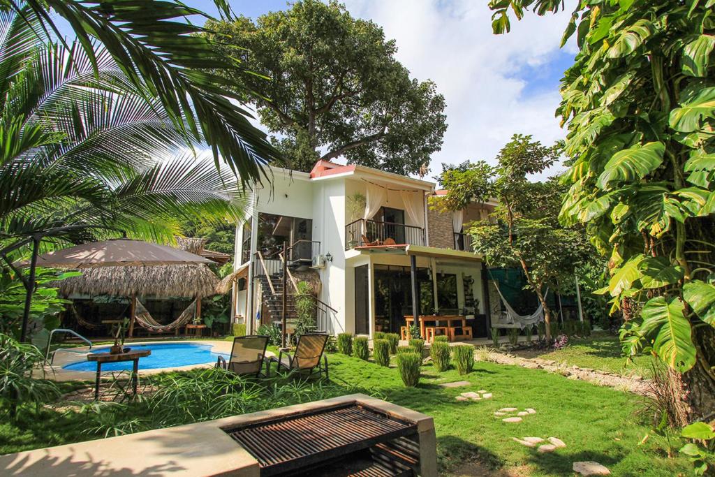een huis met een zwembad in de tuin bij El Chante Surf House in Santa Teresa Beach