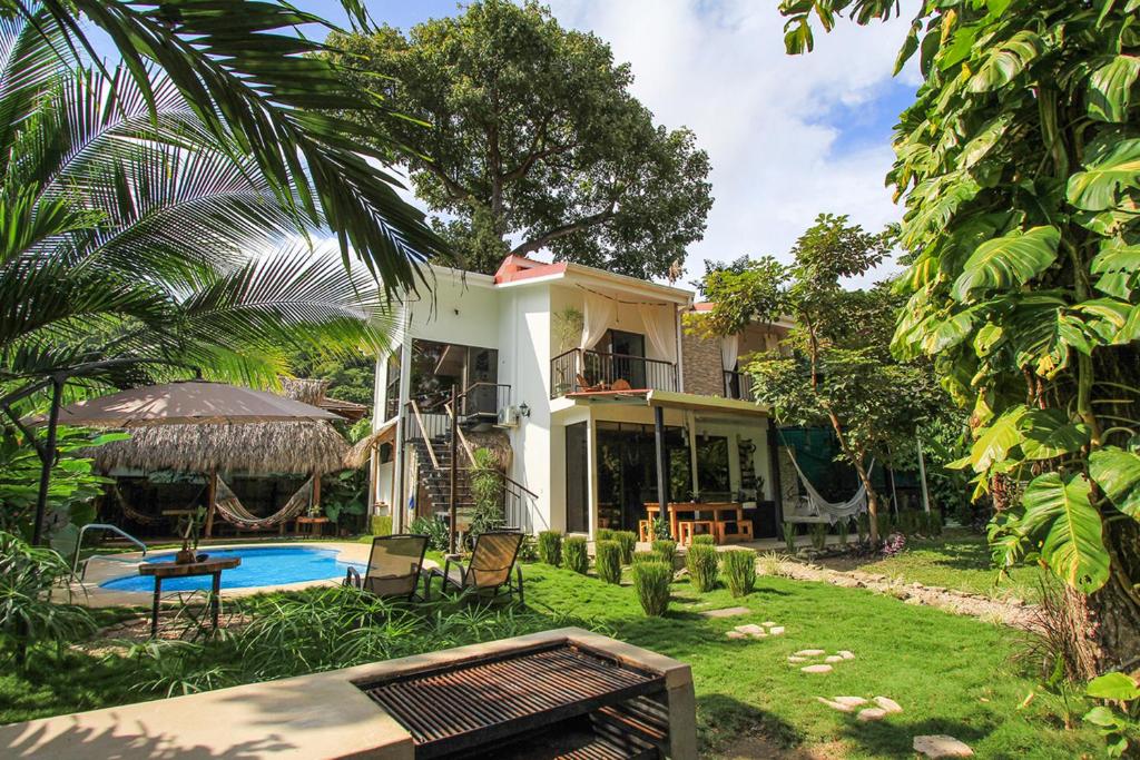 a house with a swimming pool in the yard at El Chante Surf House in Santa Teresa Beach