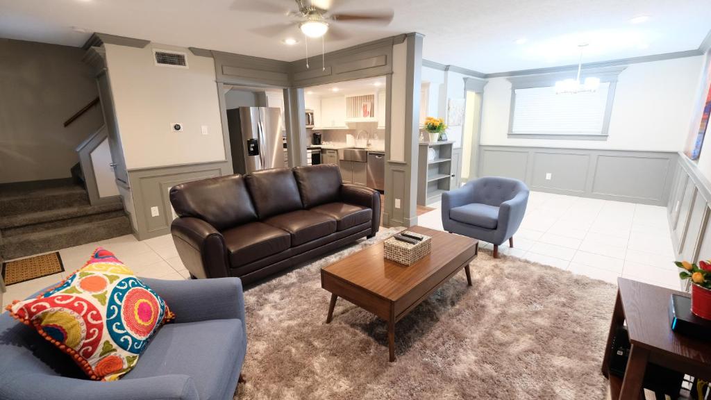 uma sala de estar com um sofá e uma mesa em Southwest, NRG, GRB, MM Park, Downtown, Galleria, Medical Center - Imogene em Houston