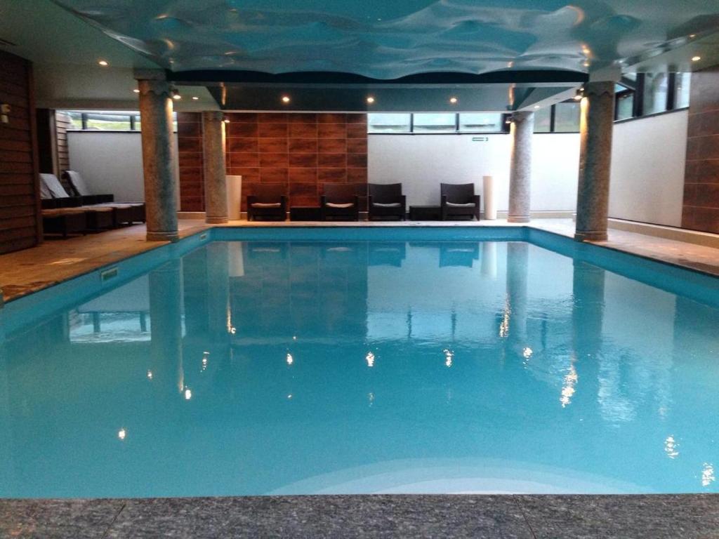 a large blue swimming pool in a building at La Ginabelle Gala in Chamonix-Mont-Blanc