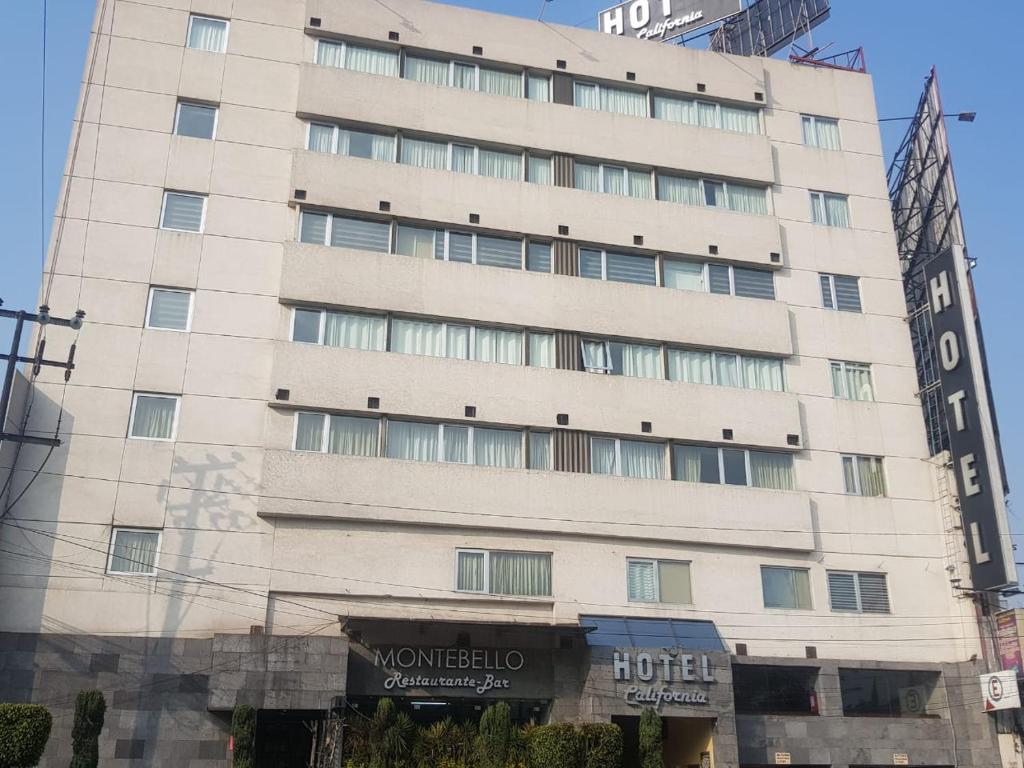 duży biały budynek z znakiem przed nim w obiekcie Hotel California w mieście Meksyk
