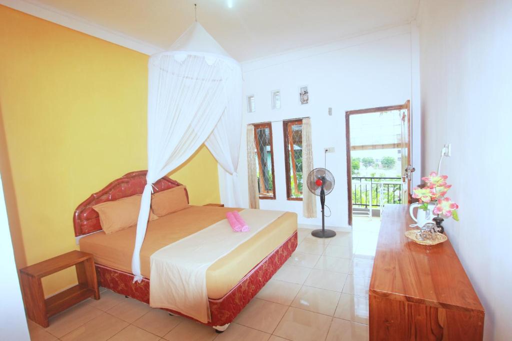 a bedroom with a bed with a canopy at Manta Manta Guesthouse in Labuan Bajo