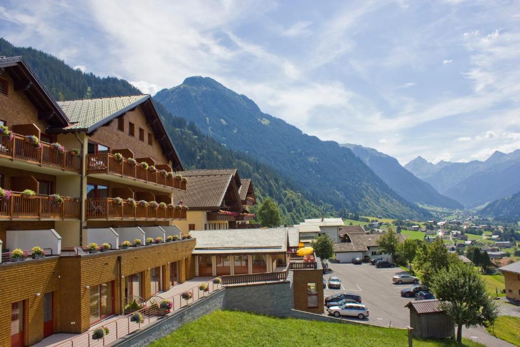 Vistas a una ciudad con montañas en el fondo en Berg-Spa & Hotel Zamangspitze, en Sankt Gallenkirch