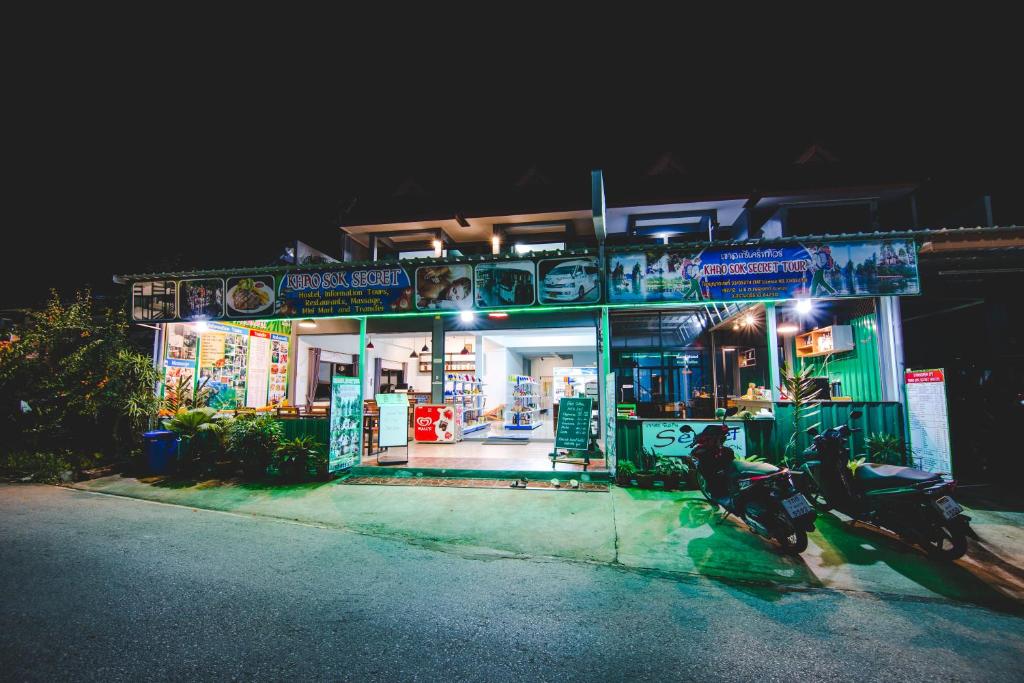 una moto parcheggiata di fronte a un negozio di notte di Khaosok Secret Hostel a Parco Nazionale di Khao Sok